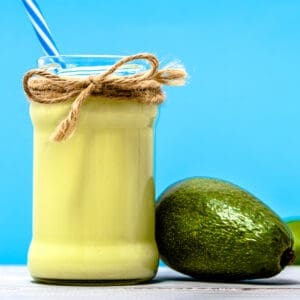 Green smoothie with avocado, shake in jar on table