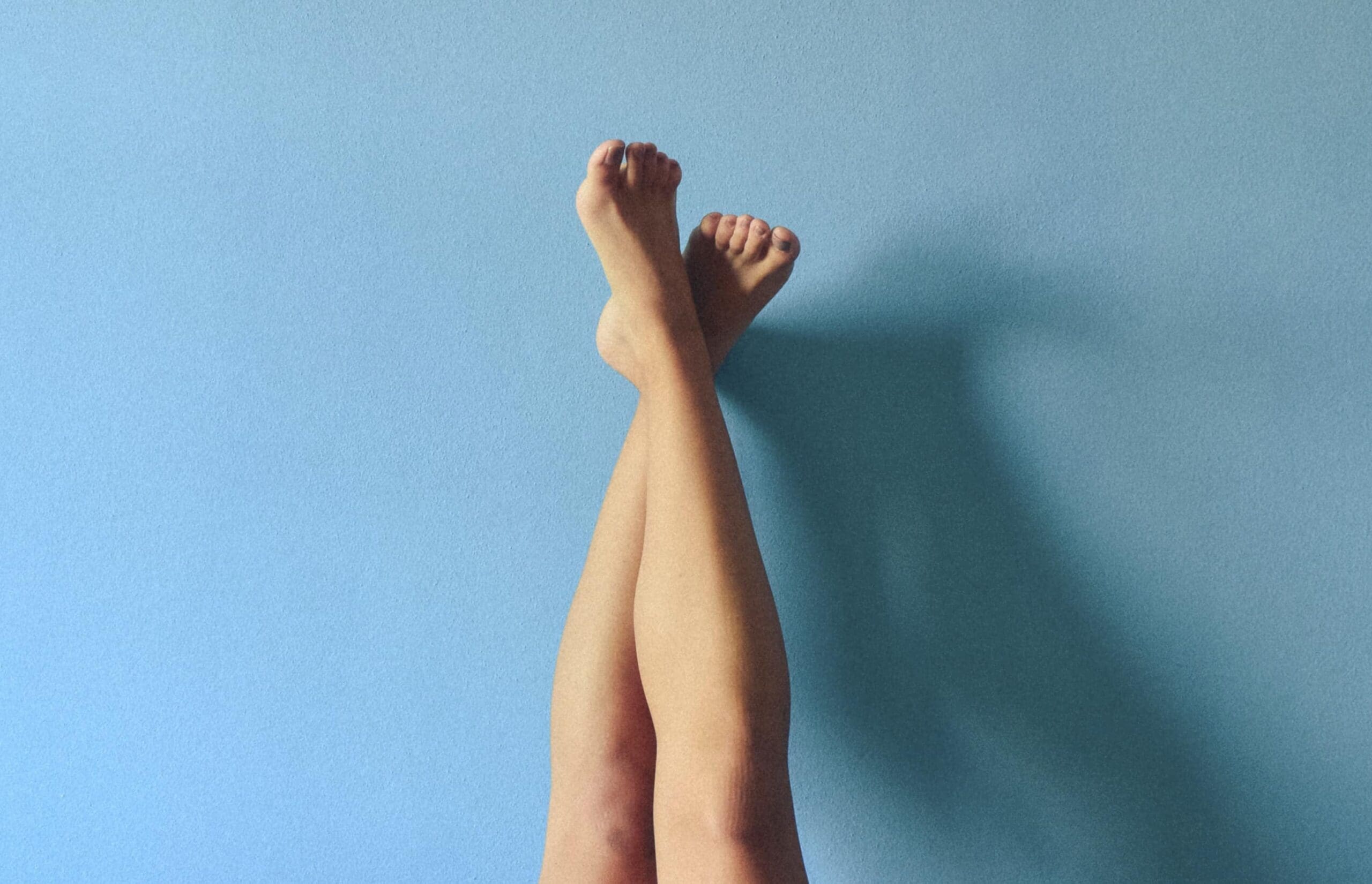 A woman with her legs up after using sore body products to treat her aches