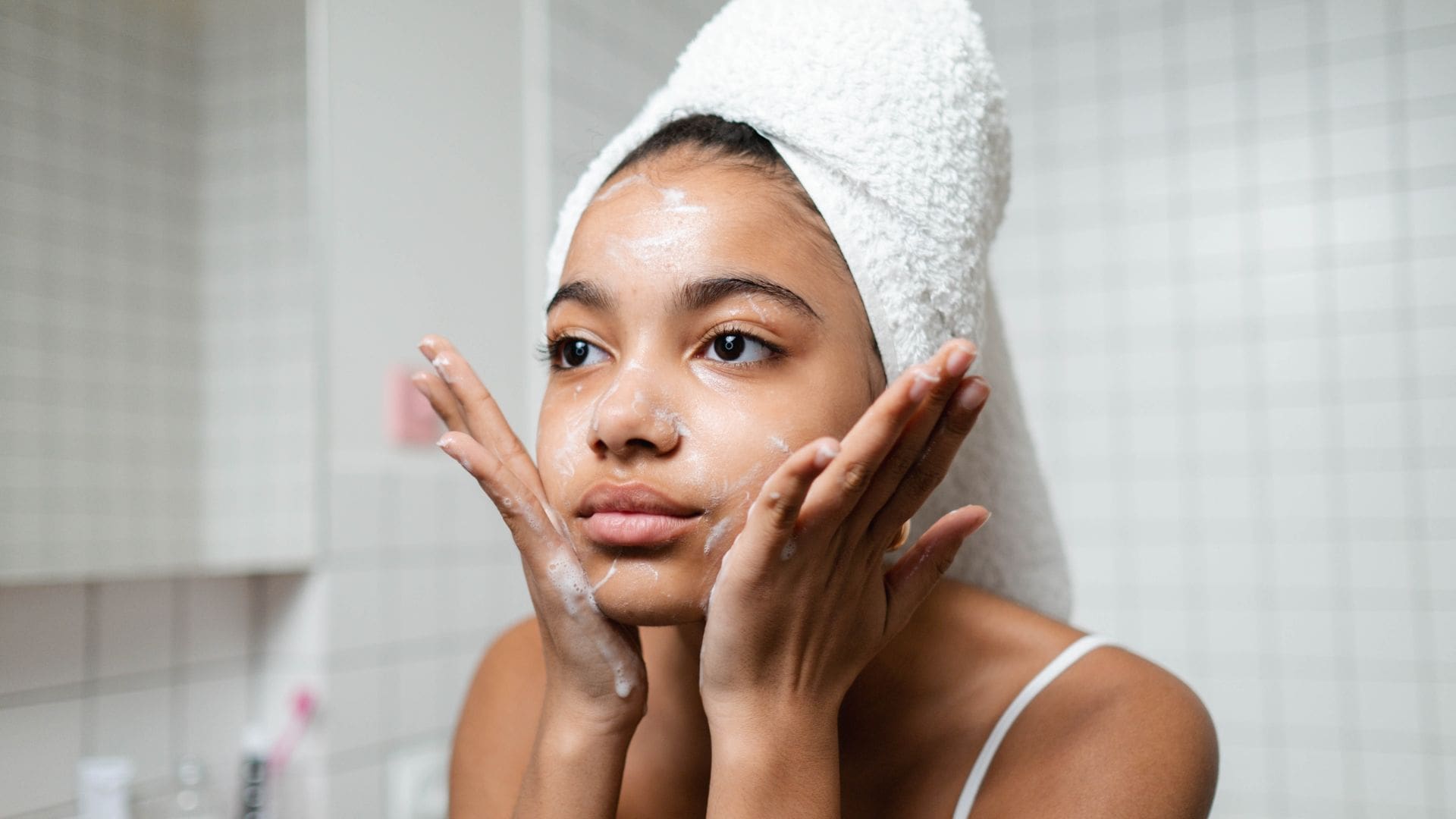 woman washing her face while skin cycling