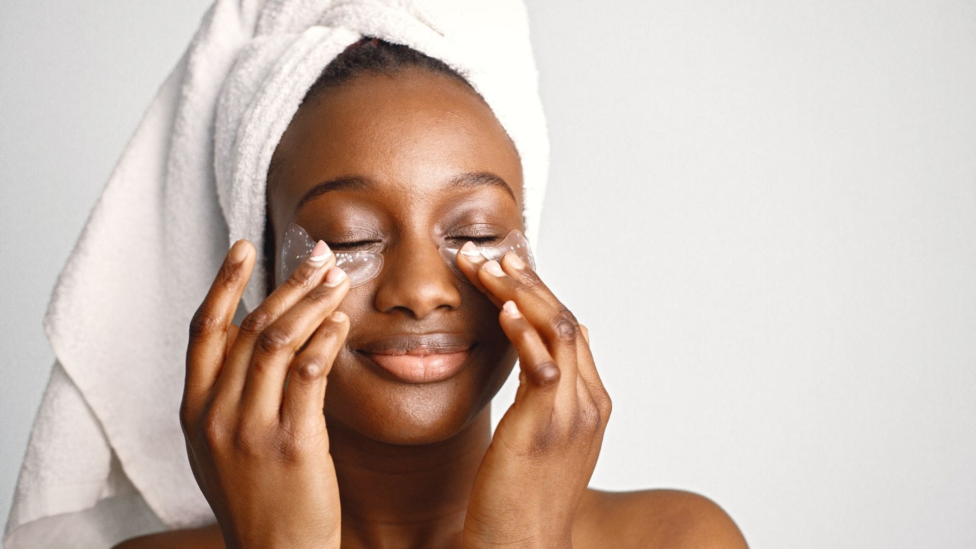black woman with eye patches engaging in skincare trends in 2024