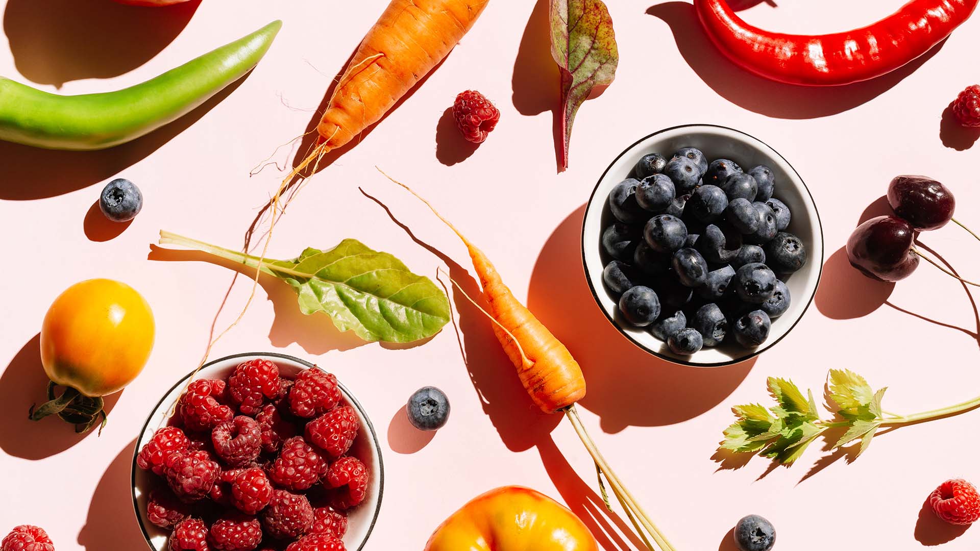 Fruit and vegetables on a pink background.