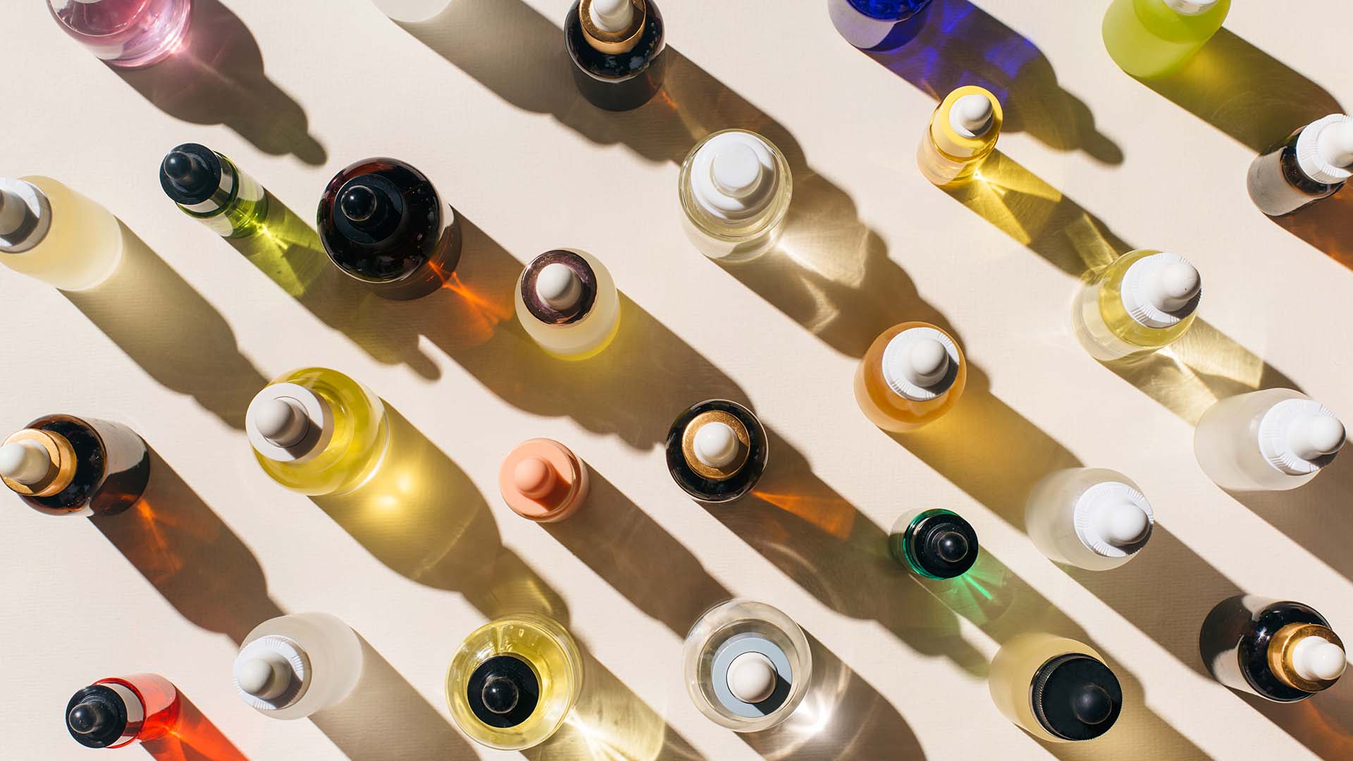 Glass bottles for cosmetic products with pipette, natural skincare and essential oil on beige background. Beauty products. Multitasking beauty, skinmalism, Skin care concept.